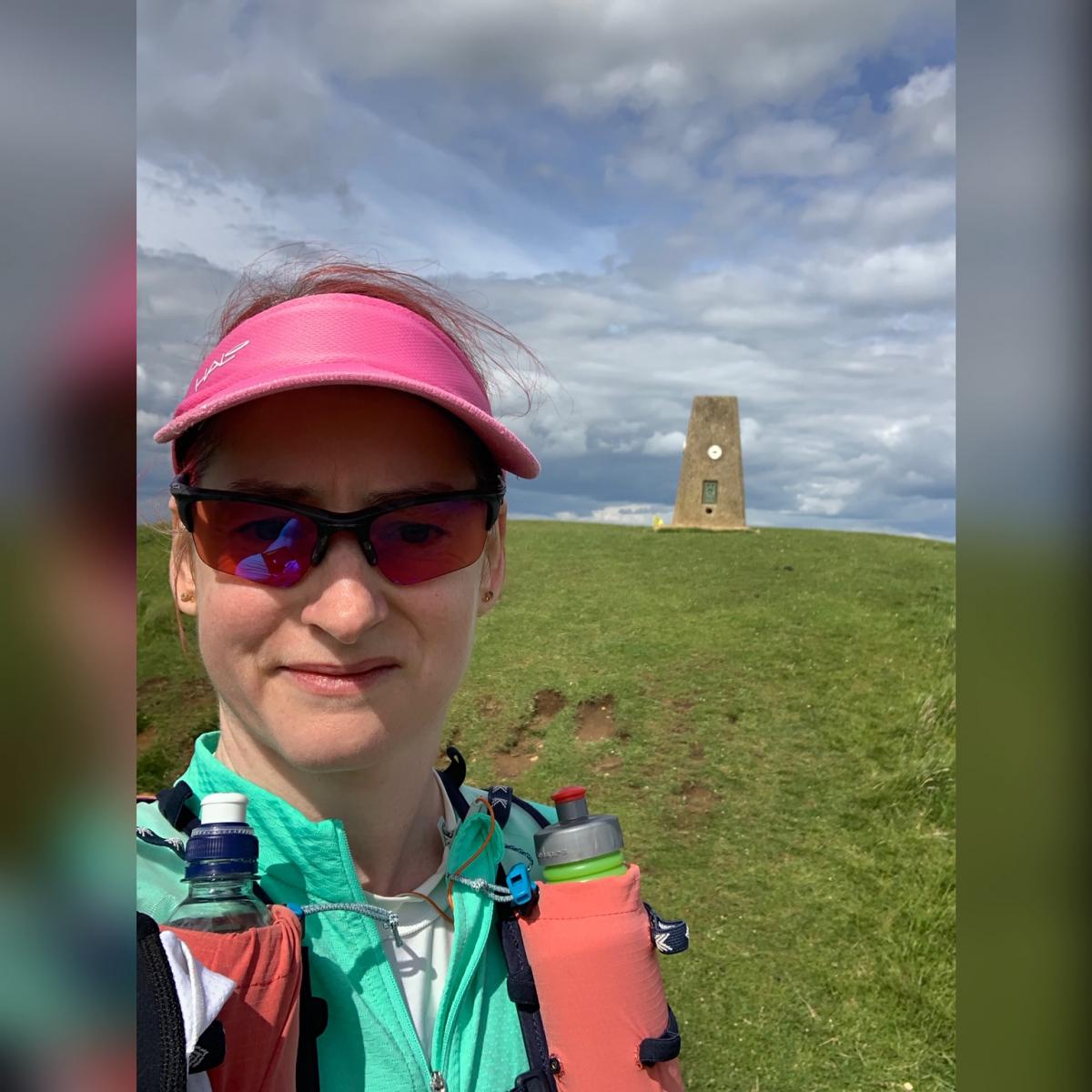 Kat takes a selfie in front of the Cleeve Common trig point
